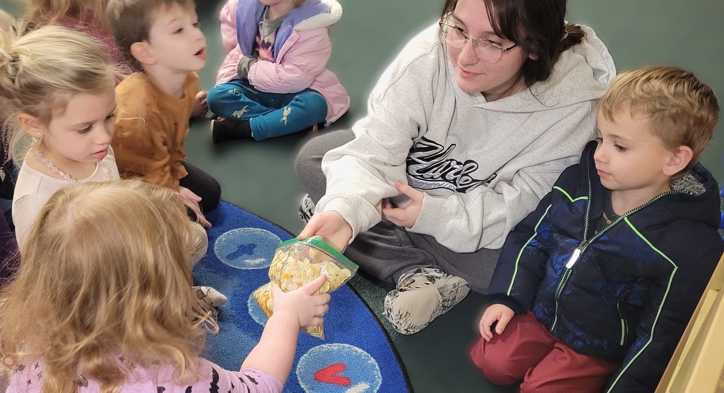 Teacher sitting on floor engaged with group of children