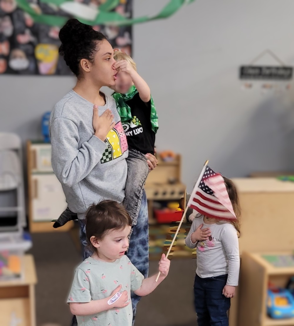 Teacher and toddlers doing the Pledge of Allegiance