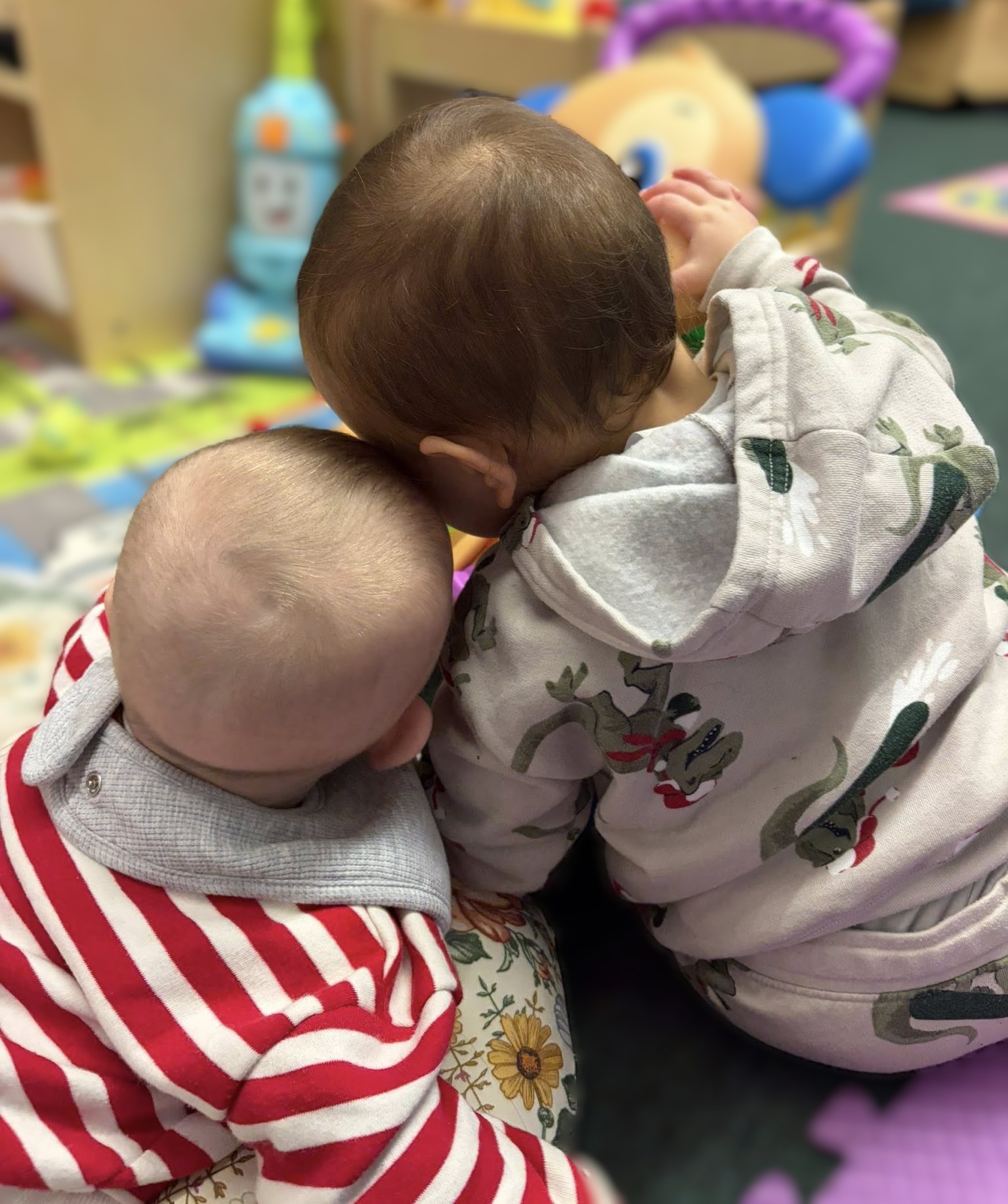 Two babies leaning on each othert