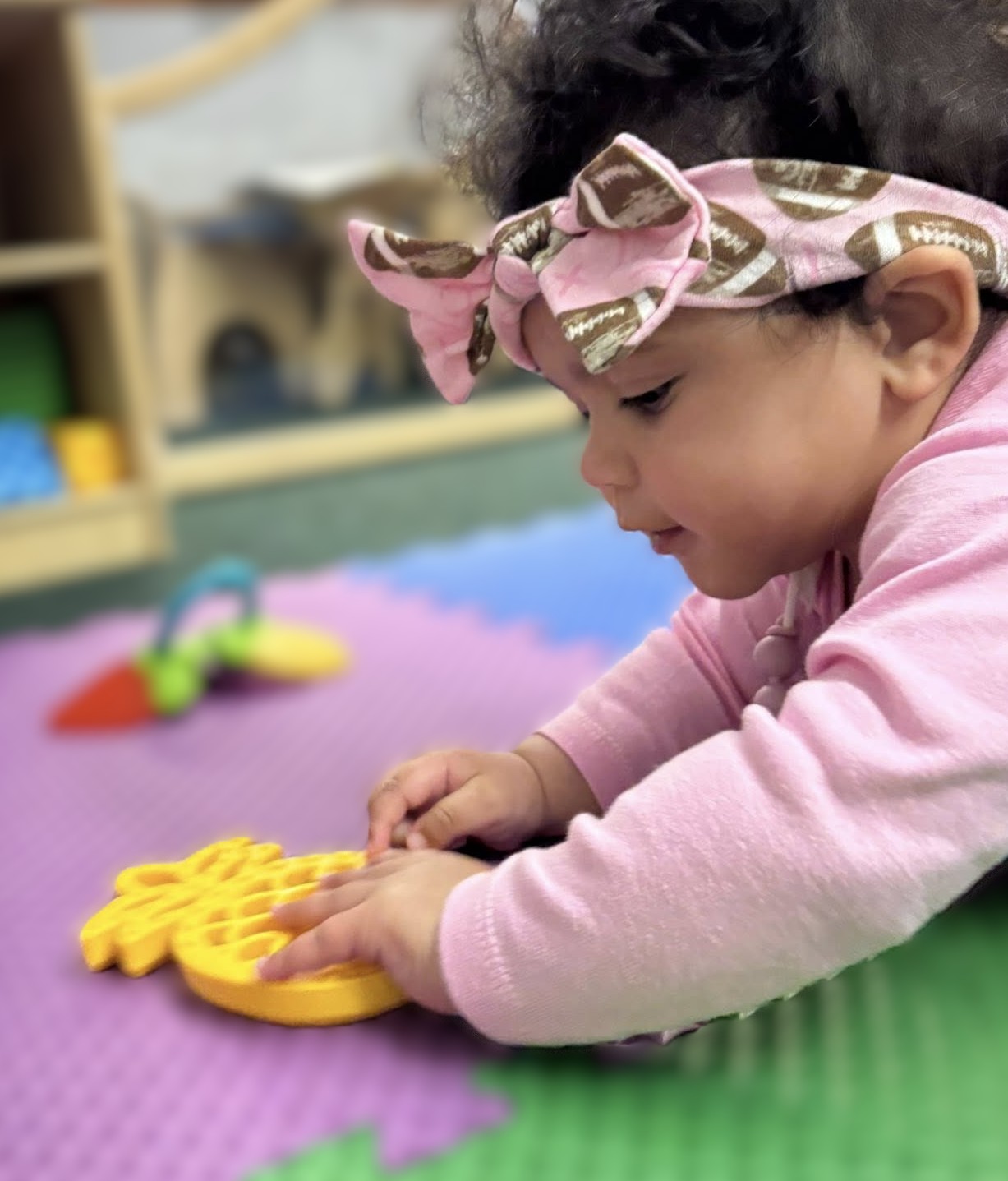 Toddler focused intently on exploring a toy