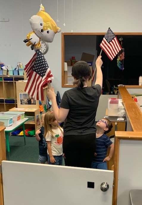 Teacher and toddlers doing the Pledge of Allegiance